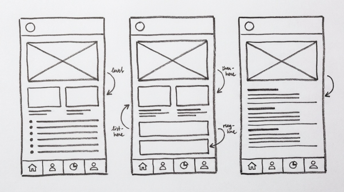 Low-fidelity mobile app wireframes sketched on paper